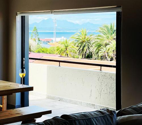 a living room with a view of the ocean from a window at Tuscan House in Hartenbos