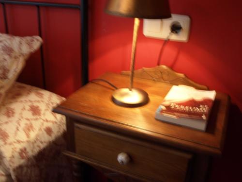a lamp on a wooden table next to a bed at Casa del Infanzón in Sos del Rey Católico