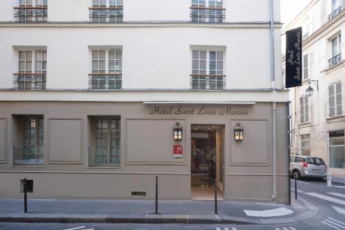 a building with a sign on the side of it at Hotel Saint-Louis Marais in Paris