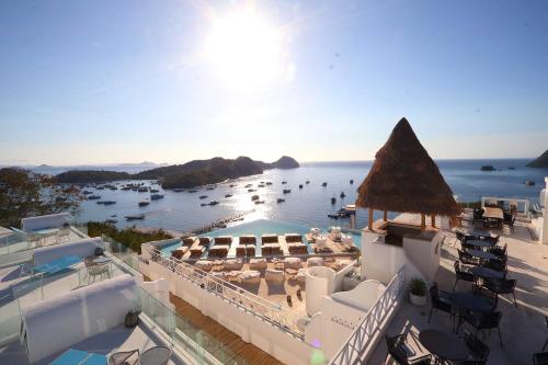 a view of a resort with a pool and the ocean at Loccal Collection Hotel Komodo in Labuan Bajo