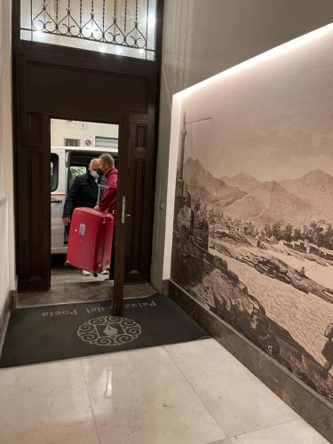 una persona che scatta una foto di un treno con una valigia rossa di Palazzo del Poeta - Dimora Contemporanea a Palermo