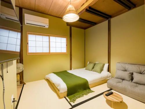 大阪的住宿－桃月庵 -Togetsuan-，一间卧室配有一张床和一张沙发
