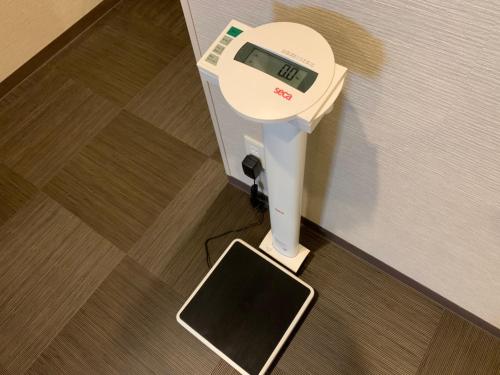 a scale in the corner of a room at Hotel Route-Inn Sakurai Ekimae in Sakurai