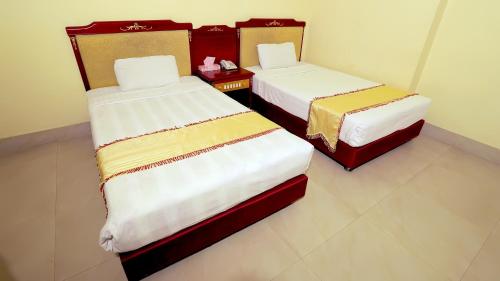 two beds sitting in a room with at Hotel Metro International in Sylhet