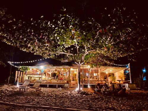 a tree in front of a building with lights at Indie Beach Bungalows in Ko Chang