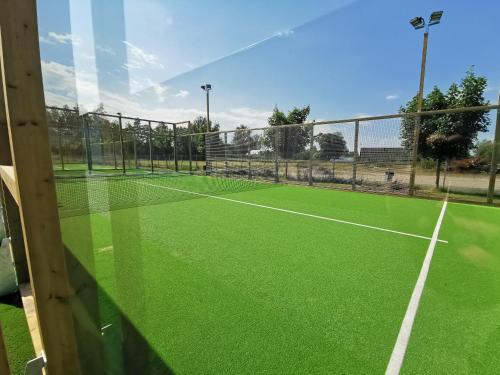 a tennis court with a green tennis court at Systemairhallen Bed&Breakfast in Skinnskatteberg
