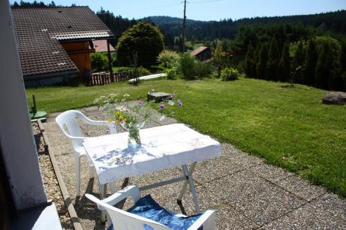 a table with a vase of flowers on a patio at Ferienhaus Marchhäuser 12 in Haidmühle