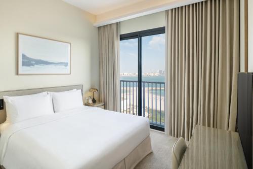 a bedroom with a bed and a large window at Vida Beach Resort Marassi Al Bahrain in Manama