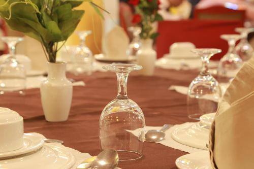 a table with white plates and wine glasses on it at Hotel Metro International in Sylhet