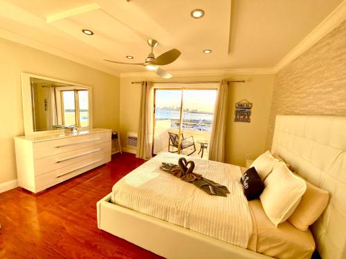 ein Schlafzimmer mit einem Bett mit einer Kommode und einem Fenster in der Unterkunft Deluxe waterfront one bedroom apartment with Miami Skyline view, free parking 5 mins drive to Miami Beach in Miami Beach