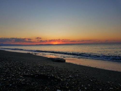 a sunset on a beach with the ocean at Malvazios Villas #8 in Gythio