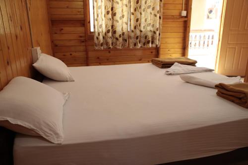 a large bed with white sheets and pillows in a room at ORANGE SKY INN HOLIDAY HOME in Canacona