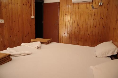 a large bed with white sheets and pillows on it at ORANGE SKY INN HOLIDAY HOME in Canacona