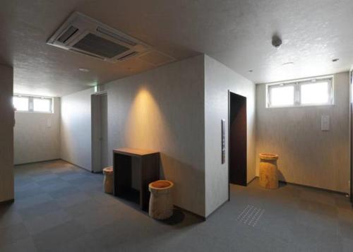 una stanza vuota con due bidoni della spazzatura e un muro di Karasuma Rokujo Hotel / Vacation STAY 3038 a Kyoto