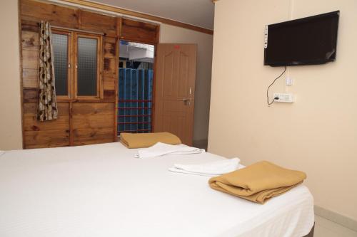 a bedroom with a bed with a tv on the wall at ORANGE SKY INN HOLIDAY HOME in Canacona