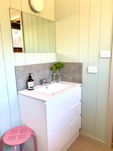 a bathroom with a sink and a pink stool at No43 Studio apartment in Mount Beauty