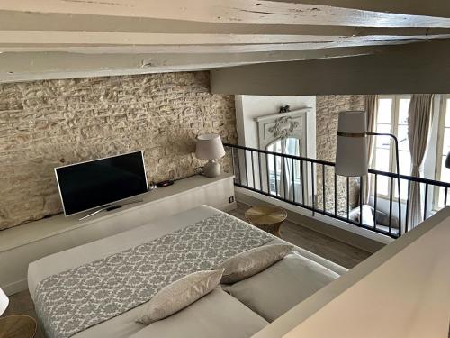 a bedroom with a bed and a tv on a wall at Le Lion des Ducs : centre historique de Dijon in Dijon