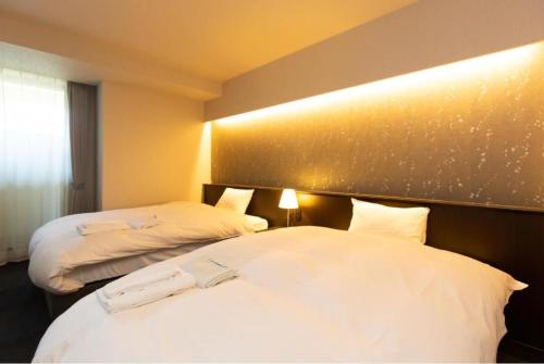 a hotel room with two beds with white sheets at Karasuma Rokujo Hotel / Vacation STAY 3036 in Kyoto