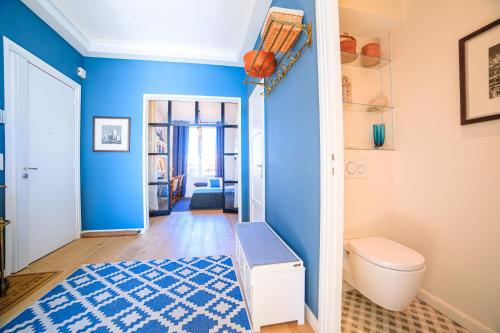 une salle de bain avec un mur bleu et des toilettes dans l'établissement Magnifique Appartement Sur La Plage Près Du Centre - Palais De La Plage, à Cannes
