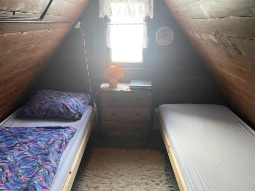 雅克摩夫的住宿－Chalupa u Šlikovky，小房间设有两张床和窗户