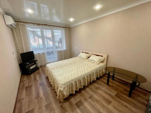 マグニトゴルスクにあるApartment Voroshilova 10のベッドルーム1室(ベッド1台、テーブル、窓付)