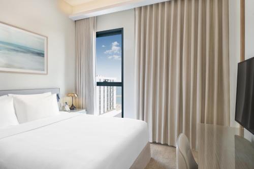 a bedroom with a bed and a large window at Vida Beach Resort Marassi Al Bahrain in Manama