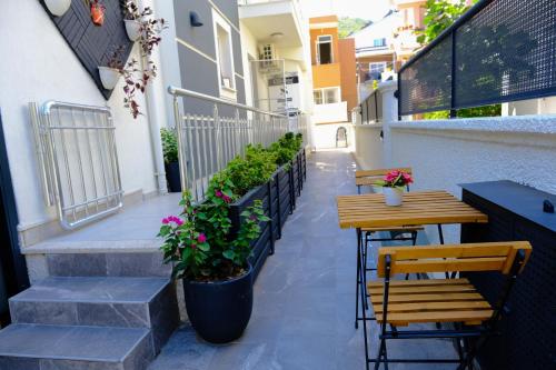 a patio with two tables and two chairs and flowers at Ozgur City Residence in Fethiye