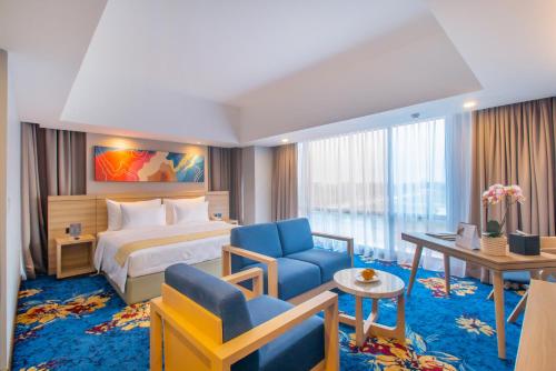 マジャレンカにあるHotel Horison Ultima Kertajatiのベッドとデスクが備わるホテルルームです。