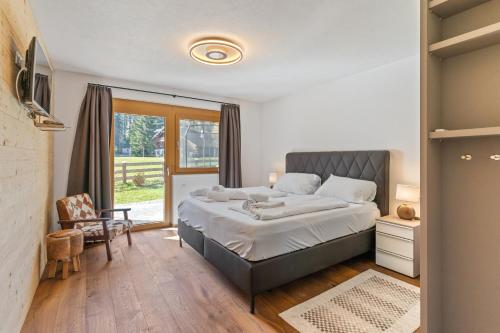 - une chambre avec un grand lit et une fenêtre dans l'établissement Chalet Wirklich Wunderbar, à Leutasch