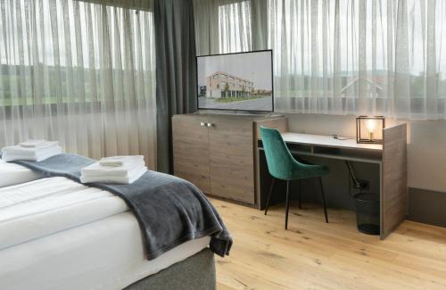Dormitorio con cama, escritorio y TV en Wyna Motel, en Neudorf