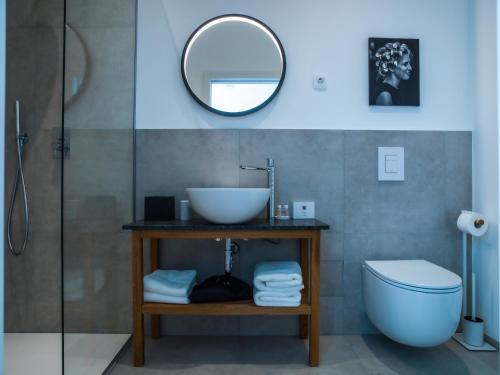 a bathroom with a sink and a toilet and a mirror at Hotel Belmur in Murska Sobota