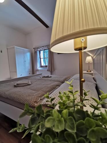 a bedroom with a bed with a lamp and a plant at Apartmány Rožmberk in Rožmberk nad Vltavou
