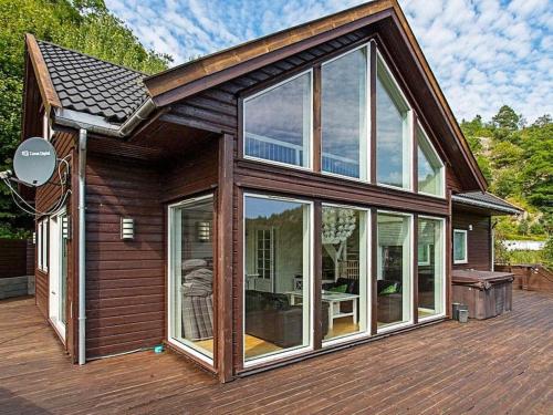 Casa con ventanas grandes en una terraza de madera en 10 person holiday home in lyngdal, en Lyngdal