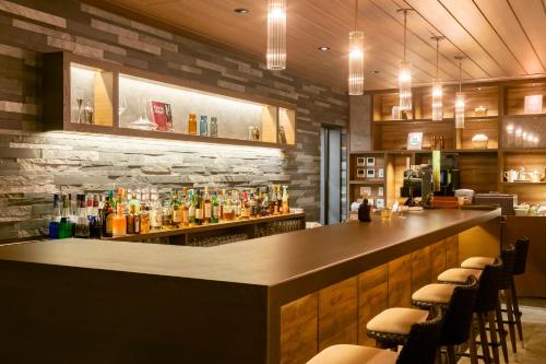 a bar in a restaurant with a stone wall at Hotel Ichibata in Matsue