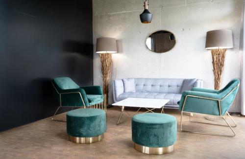 - un salon avec des fauteuils verts et un canapé dans l'établissement Wyna Motel, à Neudorf