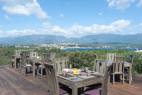 a table and chairs on a deck with a view at Le San Lorenzo in Porto-Vecchio