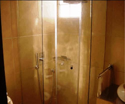 a shower with a glass door in a bathroom at Aegli Hotel in Grevena