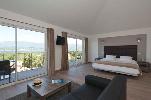 - une chambre avec un lit et une grande fenêtre dans l'établissement Le San Lorenzo, à Porto-Vecchio