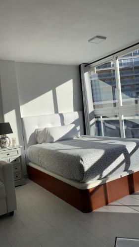sypialnia z dużym łóżkiem i oknem w obiekcie Estudio Calafin 56 w mieście Finestrat