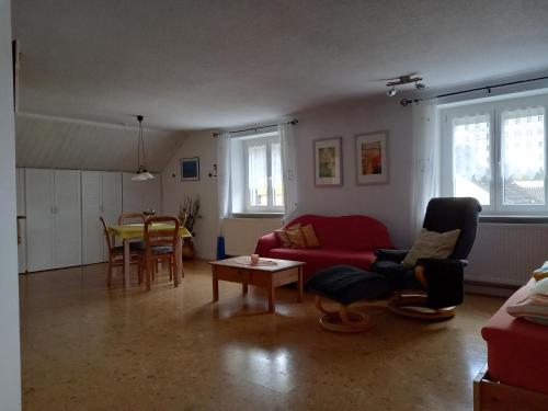ein Wohnzimmer mit einem roten Sofa und einem Tisch in der Unterkunft Ferienwohnung Agnes in Nonnweiler