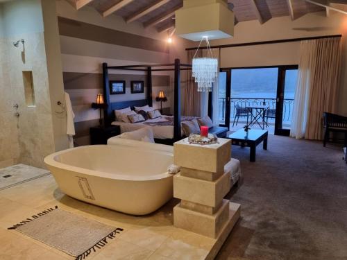 a large bathroom with a tub and a bedroom at Lodge on Lake in Wilderness