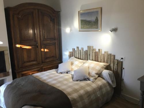 a bedroom with a bed with a wooden headboard at Petit cocon dans le Luberon in Lauris