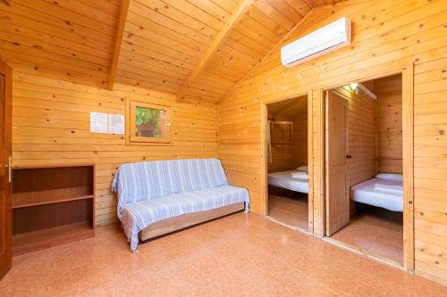 Habitación con banco en una cabaña de madera en Bungalows Camping el Cid, en Peñíscola