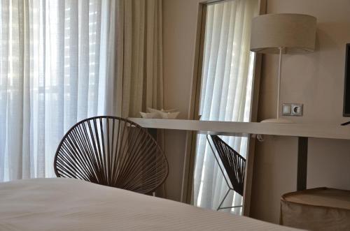 a bedroom with a bed and a table and a window at Ino Hotel & Suites in Samos