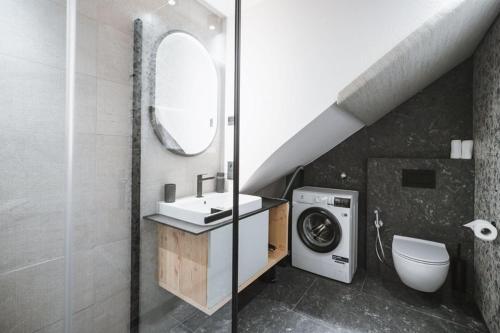a bathroom with a sink and a washing machine at AHRN Natur Apartment in Lutago