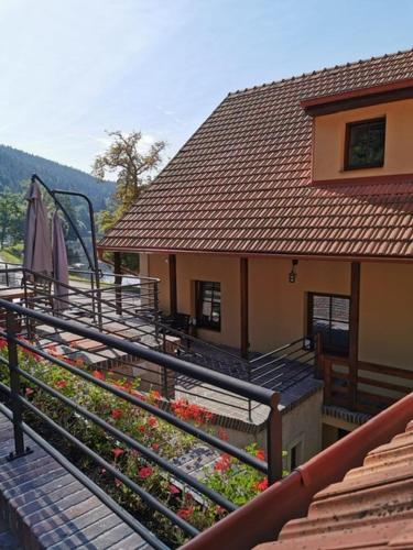 a house with a balcony with umbrellas and flowers at Apartmány Rožmberk in Rožmberk nad Vltavou
