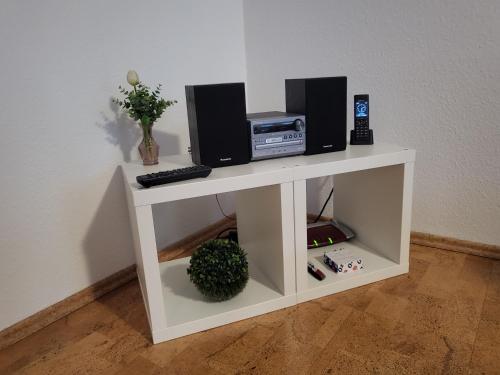 a white shelf with two speakers and a computer on it at Mucki´s Ferienwohnung in Bad Zwischenahn