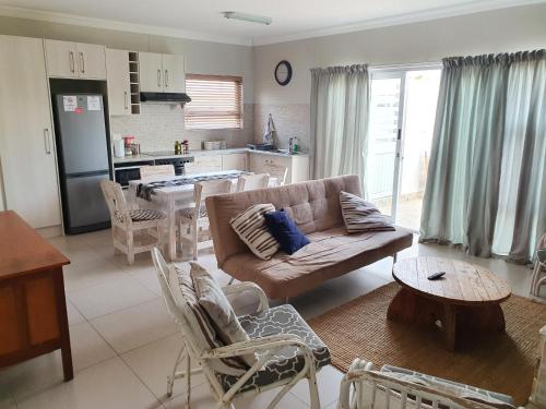 a living room with a couch and a kitchen at Acacia Four Seven Self-Catering in Swakopmund