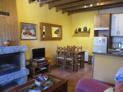 Casa Rural Fuente Tía Canora في Solosancho: غرفة معيشة مع مطبخ وغرفة طعام