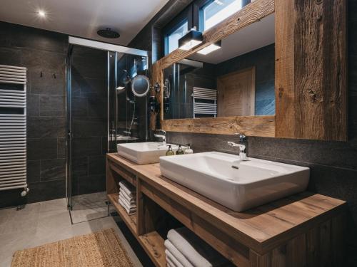 a bathroom with two sinks and a large mirror at VAYA Galtür Paznaun in Galtür